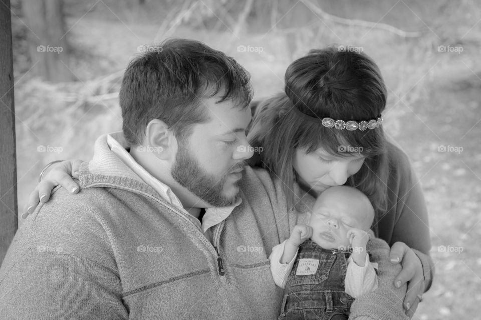 Black and white family pose with newborn baby boy
