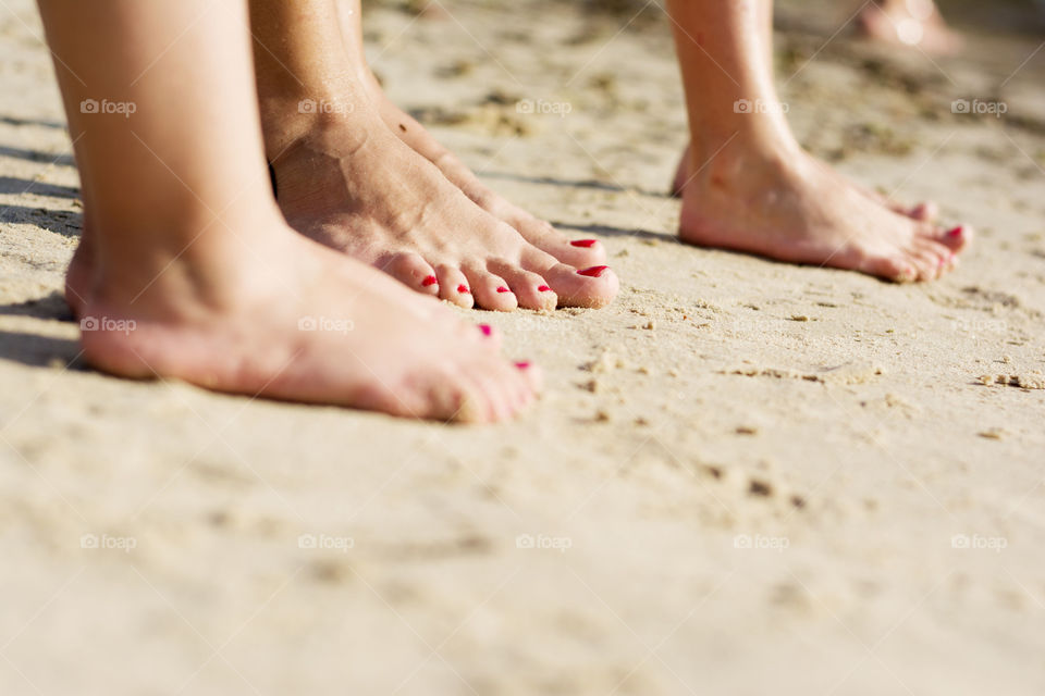 family feet. mother and daughters feet on the beach