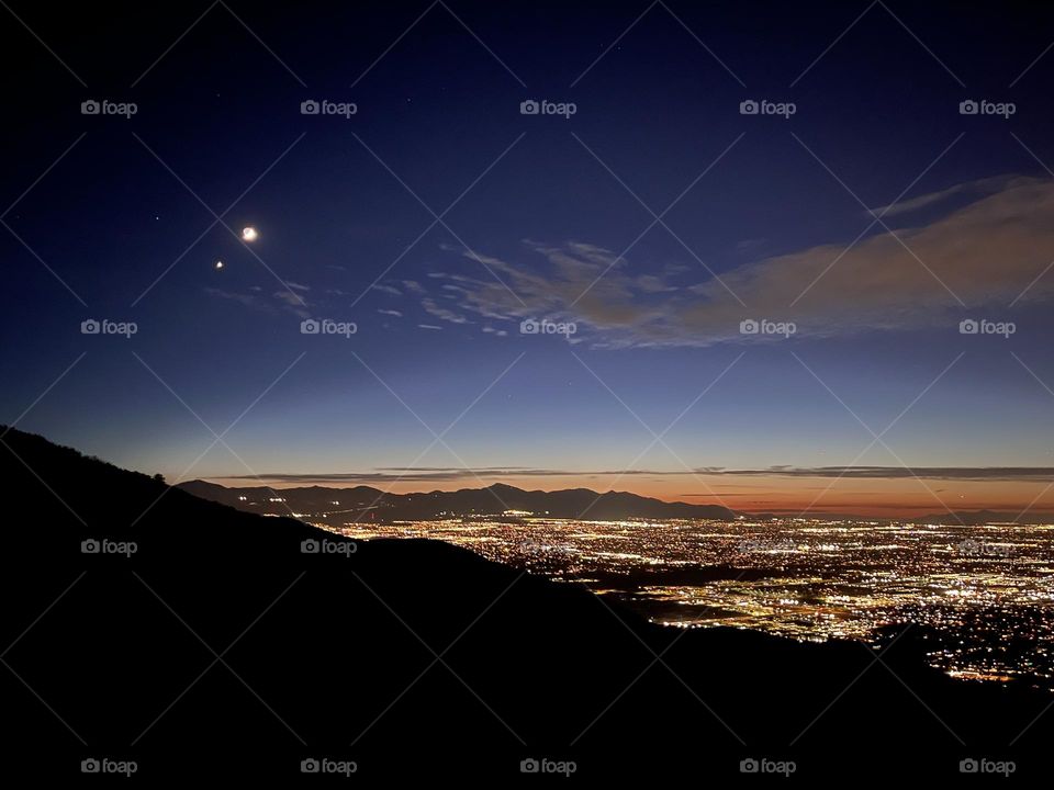 Looking out over Salt Lake City and surrounding suburbs during a warm summer sunset/moonrise 