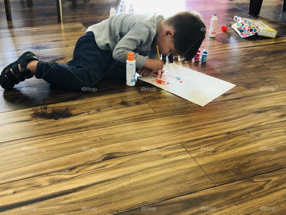 Child painting on floor