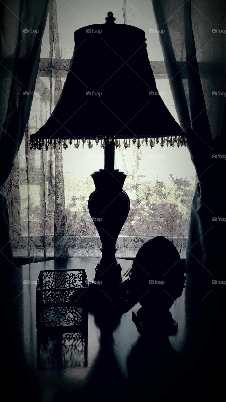 Table accents are silhouetted in front of a home window.