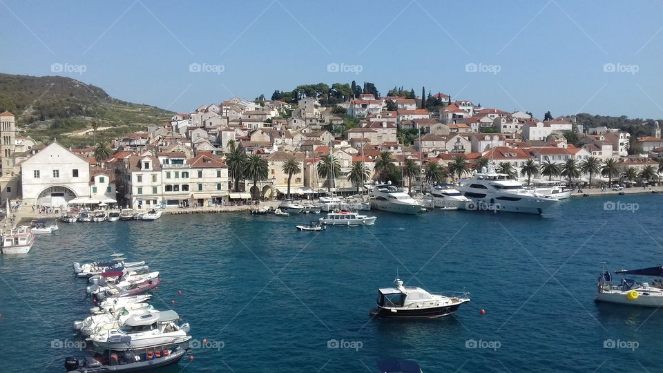 One part of panorama of Hvar City . Evning in the Hvar Habrour. Blue sea and the sun makes the perfect conection with the city. Picture is taking with my cellphone.