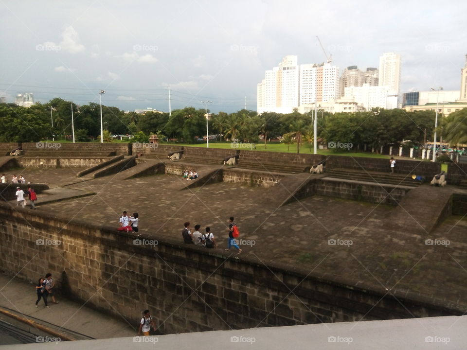 the view of the walled city of Intramuros in contrast to the modern skyline of Manila.