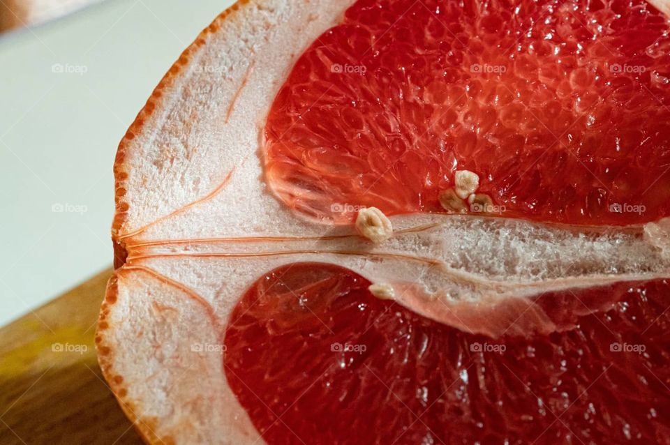 closeup of a cut grapefruit with pulp, seeds and zest