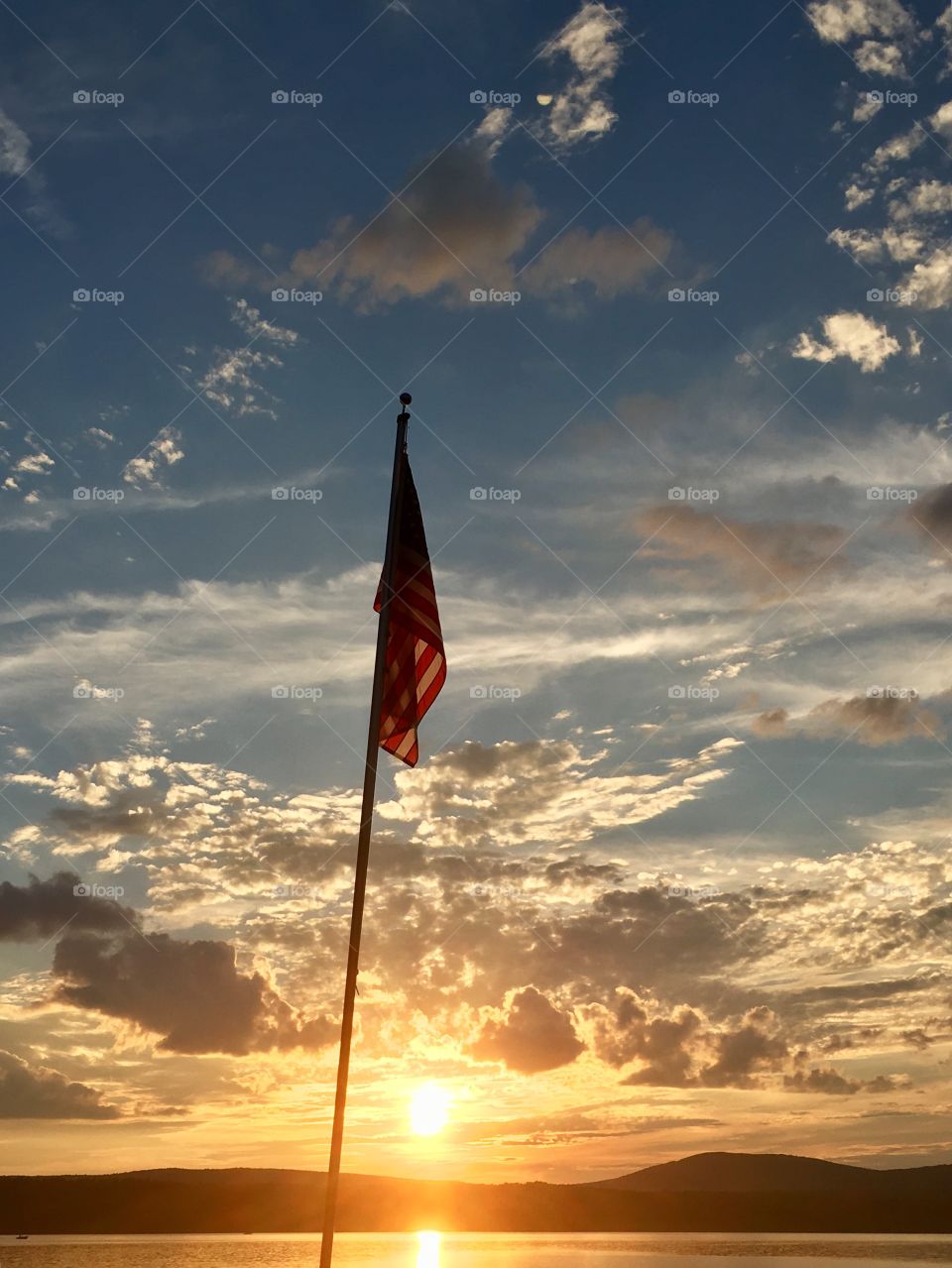 American flag at sunset on lake in adirondack mountains 