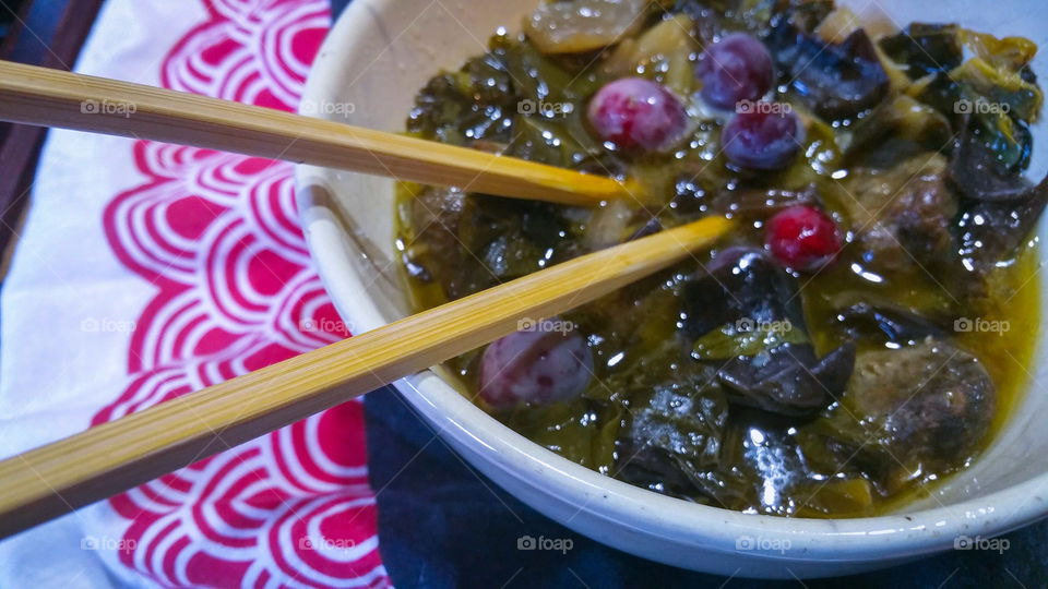 Food in a bowl, focus on the chopsticks