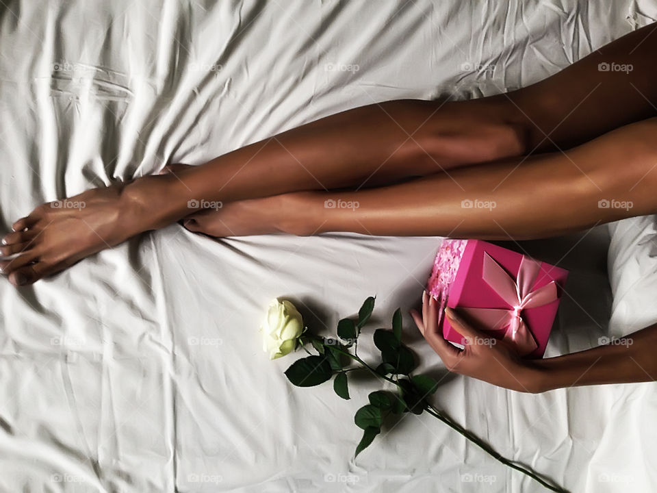 Gift box and rose in bed 