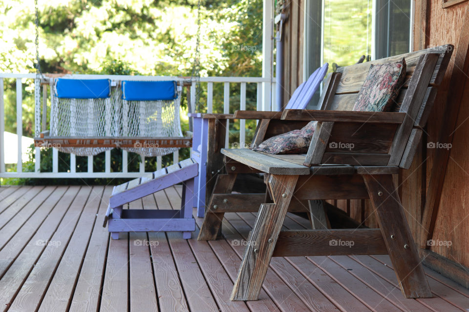 Wooden chair and swing on the porch, country living