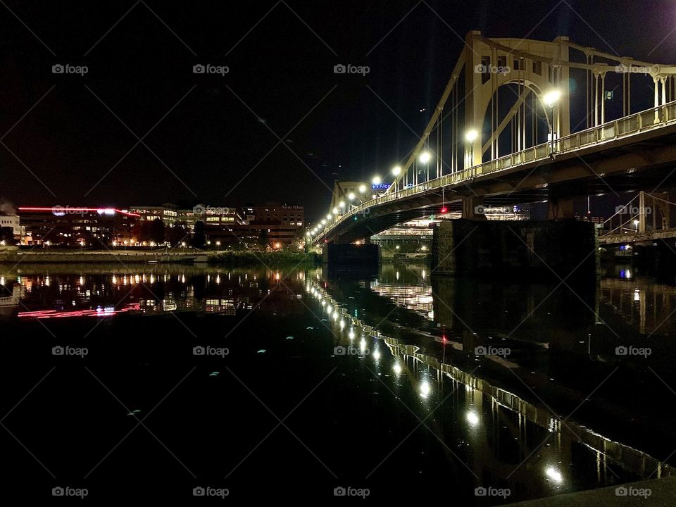 The Rachel Carson bridge in Pittsburgh Pennsylvania at night the crosses over the Allegheny river the river water looks so calm that the bridge is reflection was almost perfect