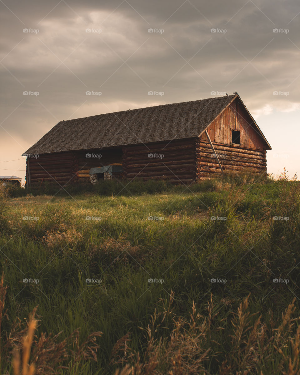 Old rustic barn during golden hour with some moody clouds