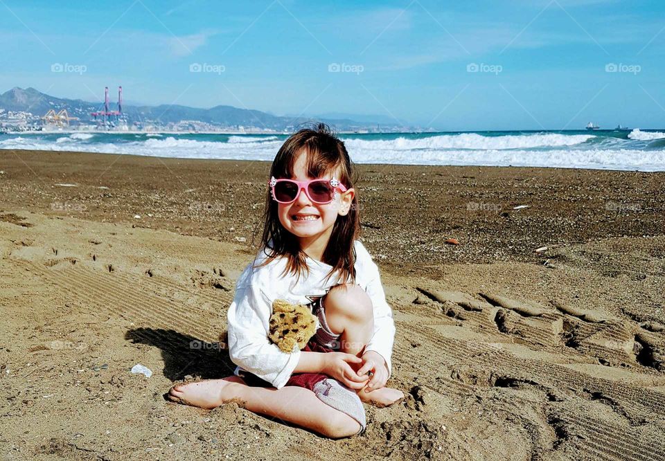 Little girl at beach with sunglasses