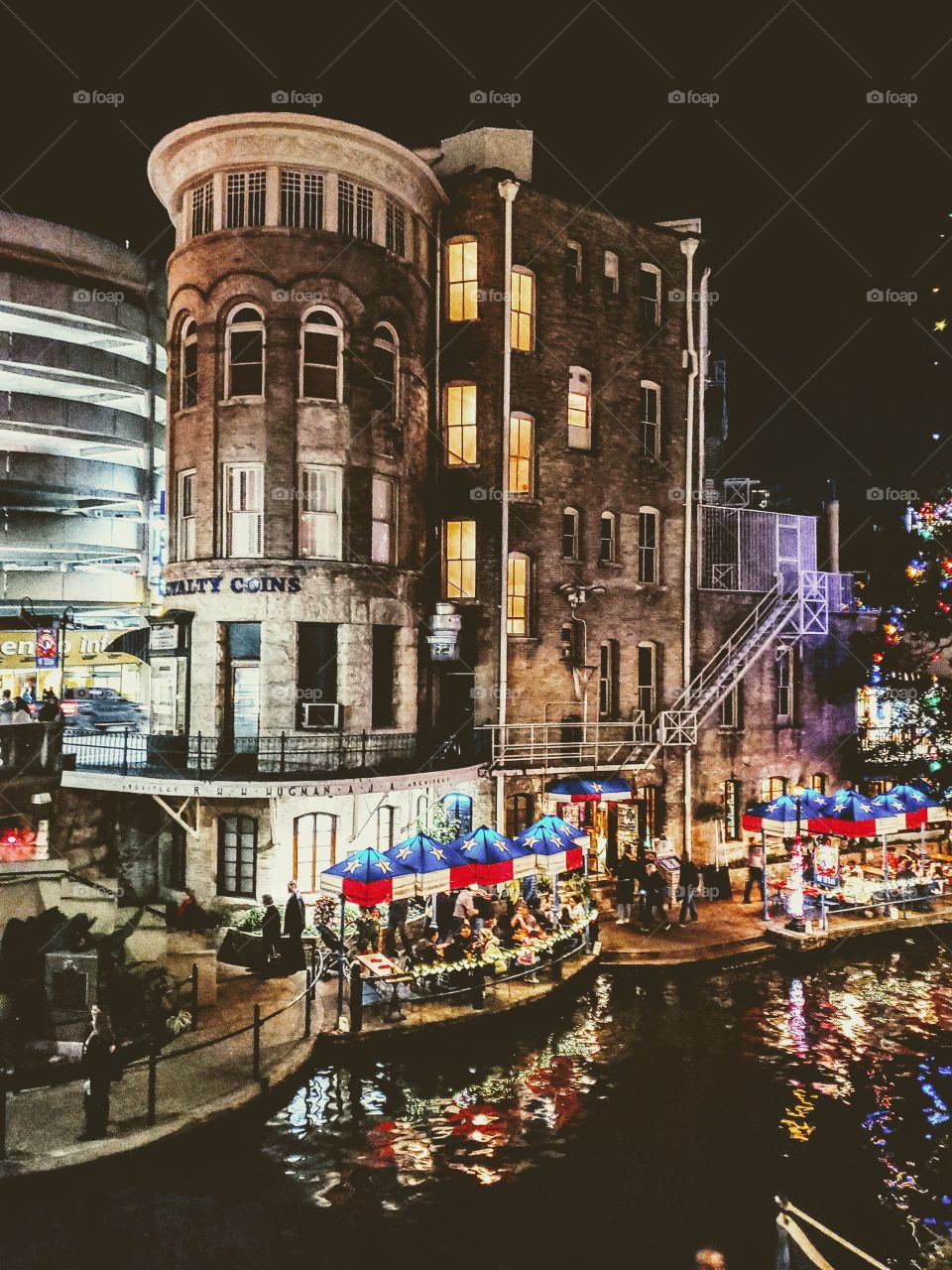 Nightlife photo with an Old cylinder shaped brick building off of the riverwalk in downtown San Antonio, Texas