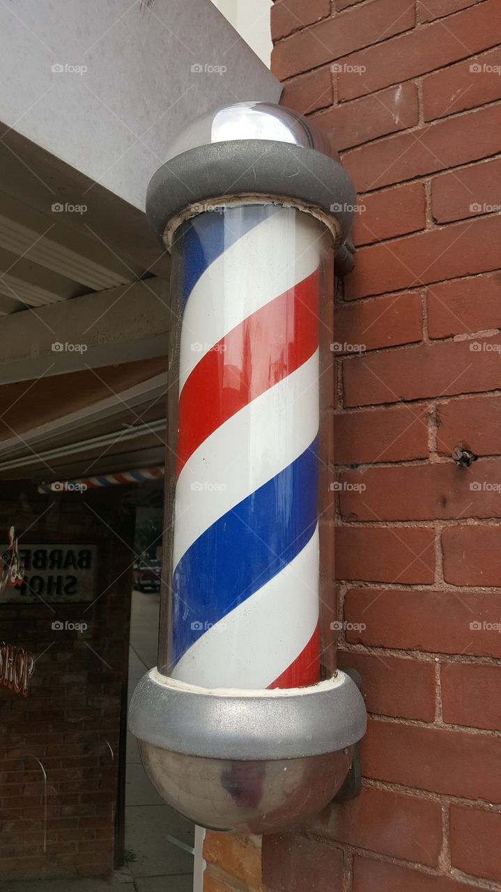 vintage Barber sign red white blue off brick wall