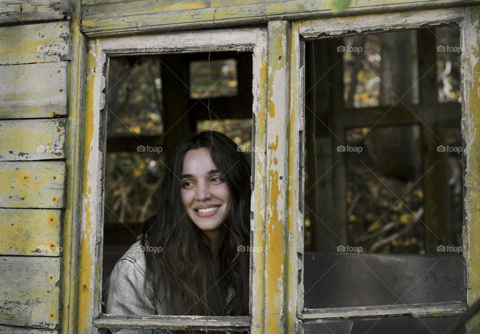 Beautiful woman portrait on the window, smiling