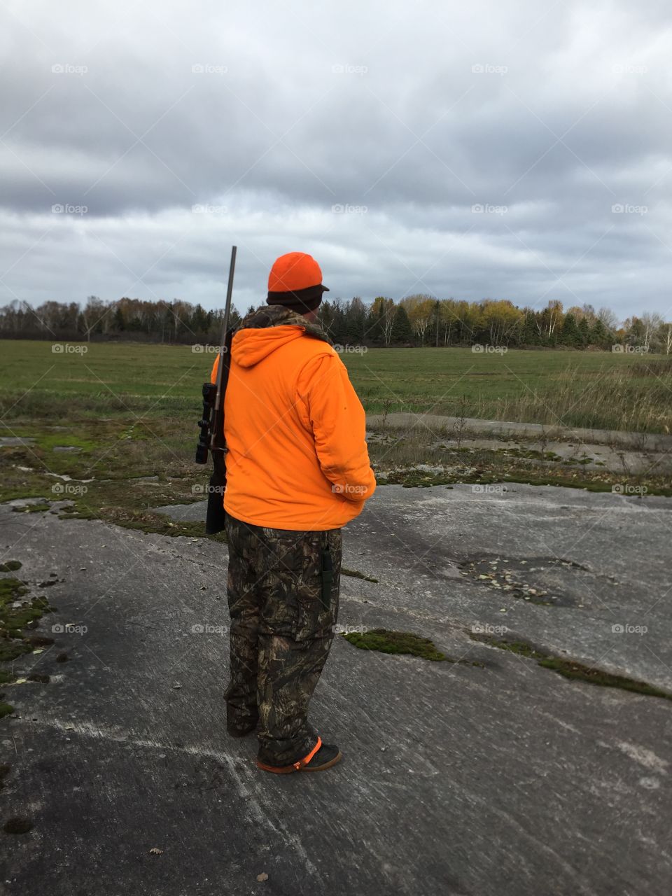  crisp Cool sunny day getting ready for the hunt sporting his orange and camouflage gear .The sport at the Hunt