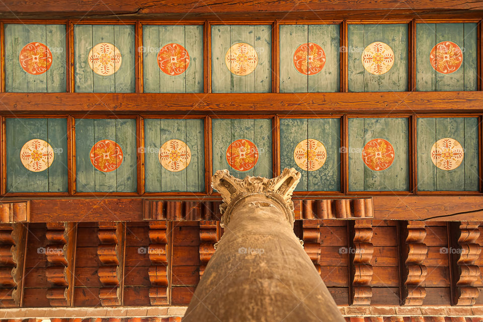 Beautifully decorated ceiling supported by ancient column.