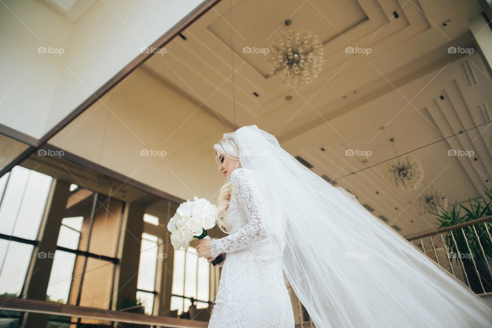 Bride in wedding dress hold roses bouquet of roses
