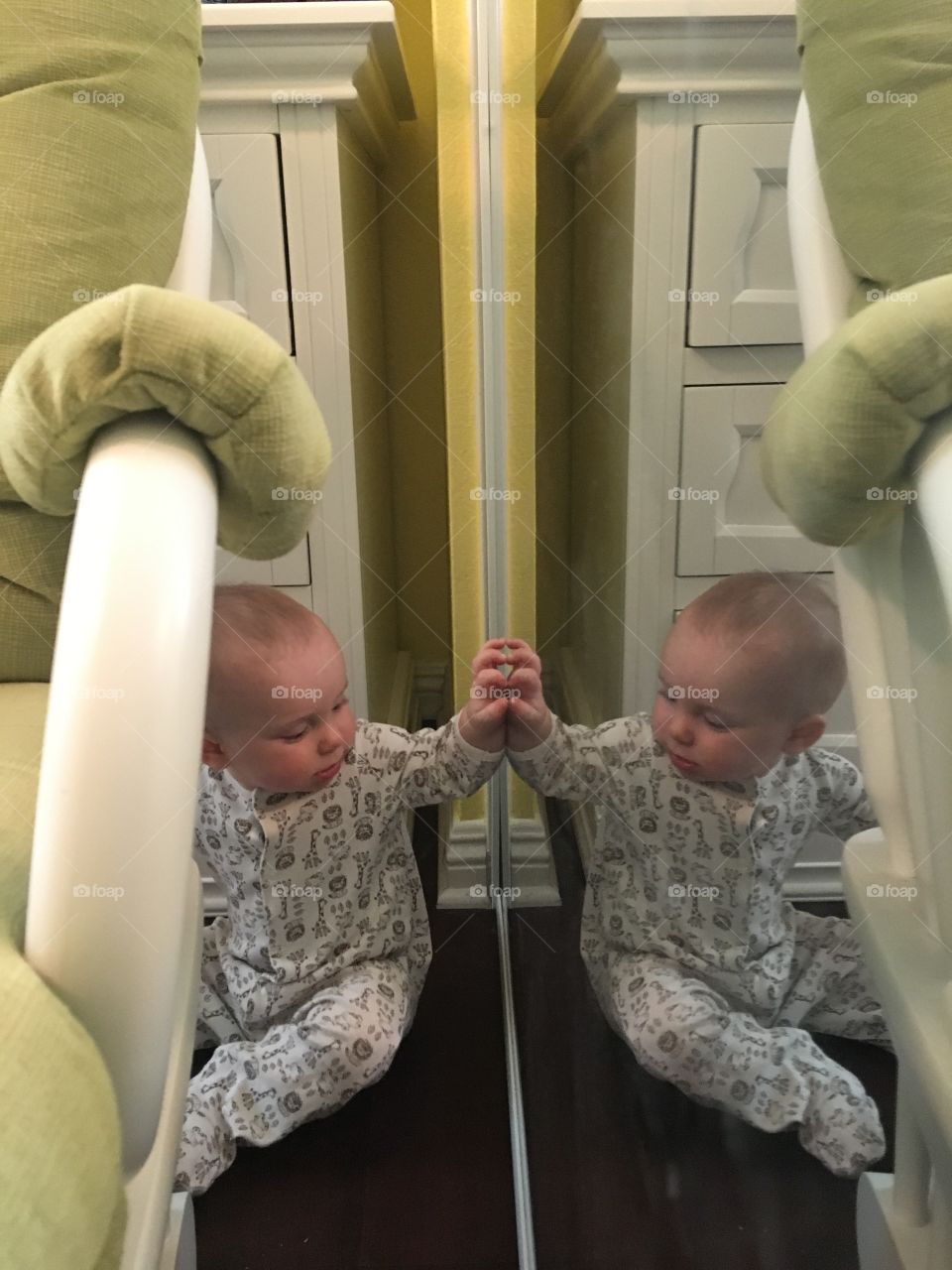 Cute baby boy reflecting in mirror