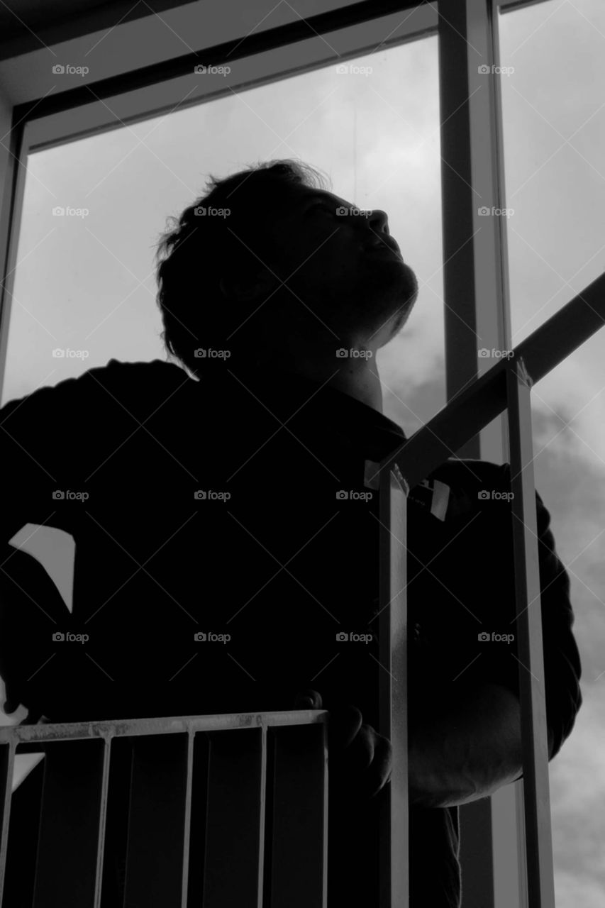 man standing beside fence