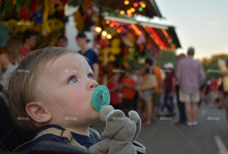 Cute baby boy taking in the sights at a street festival 