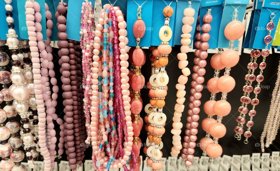 shiny bright pink jewelry bead strands for sale in an Oregon craft supply store give barbie glam style vibes