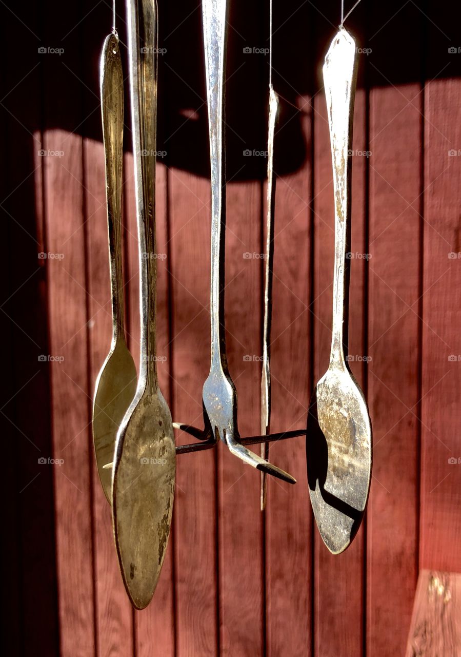Folk art wind chimes on country porch