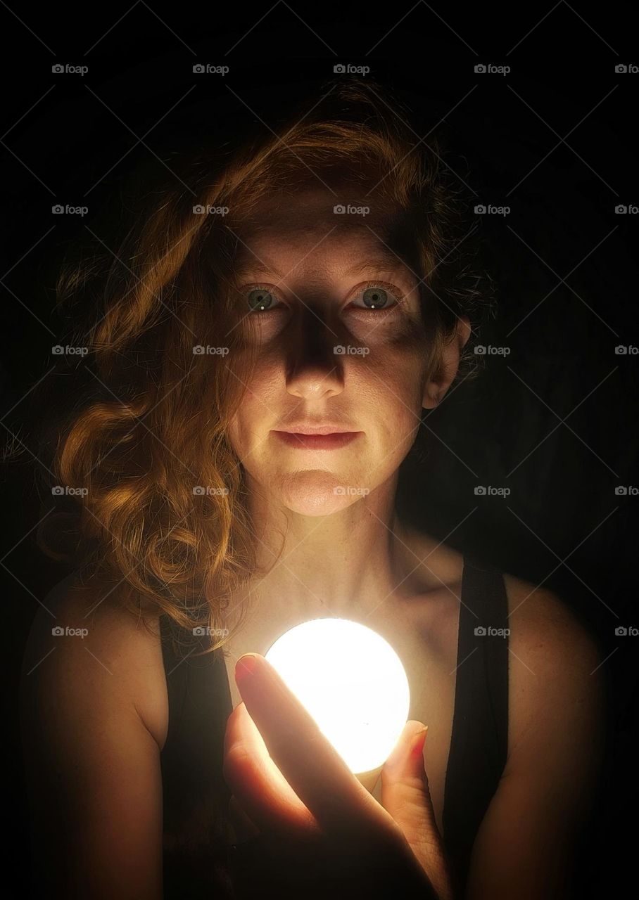 Portrait of a girl holding a ball of light.