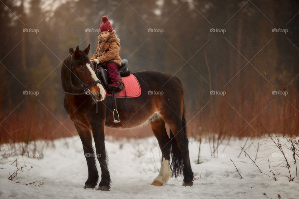 Little girl with horse outdoor portrait at spring day