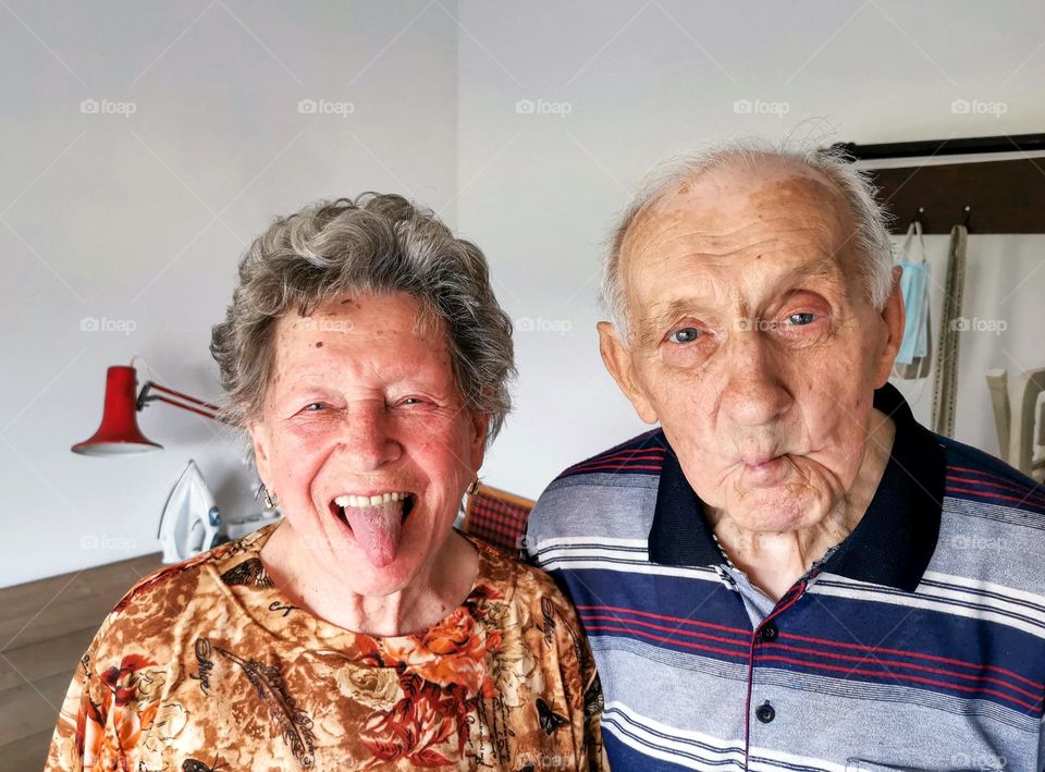 Portrait of happy senior couple making silly faces while looking at camera