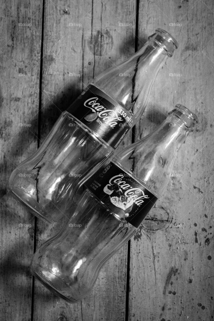 black and white bottles of Coca cola on a wooden table