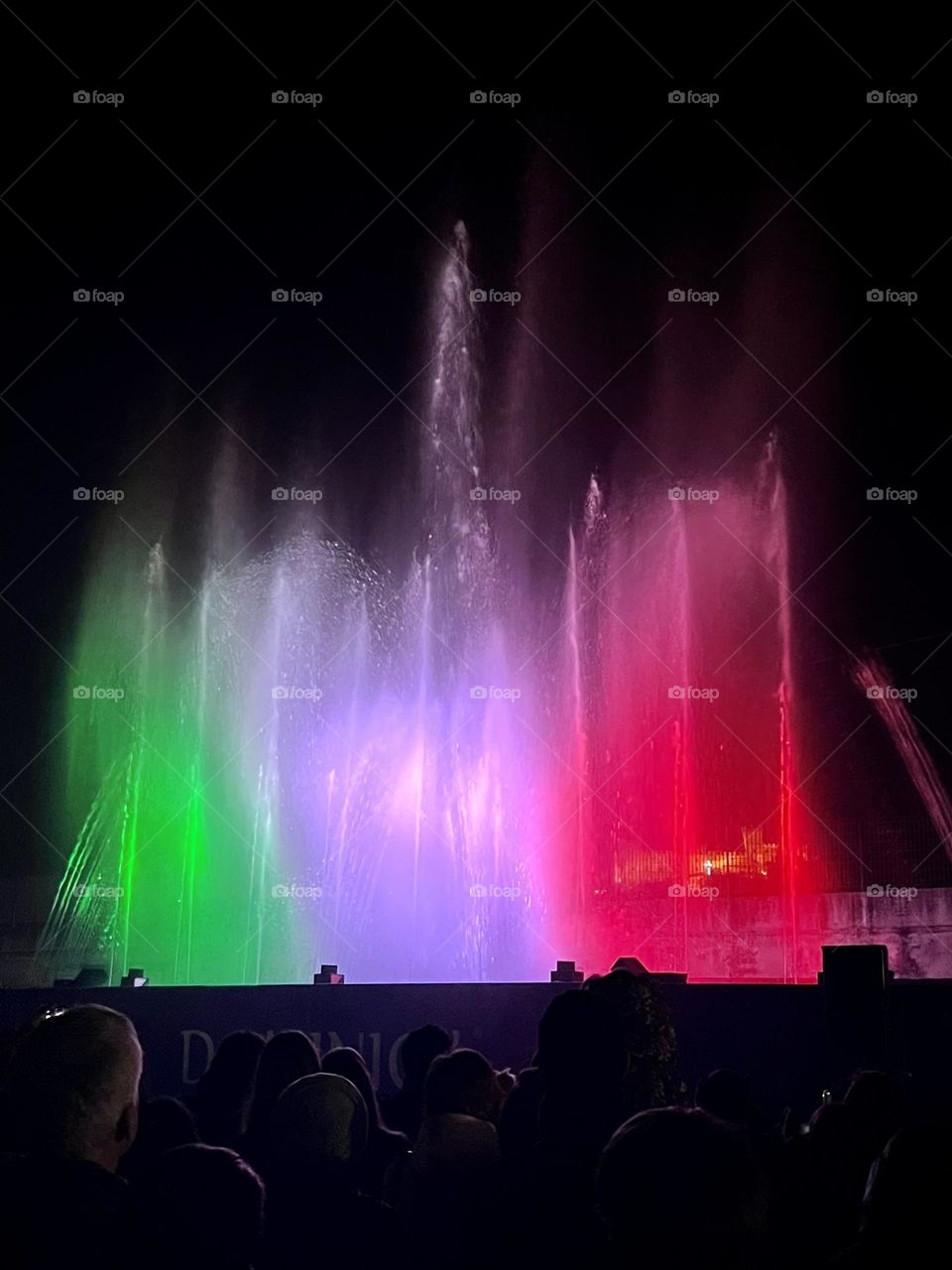 People enjoying the colorful fountain in the night