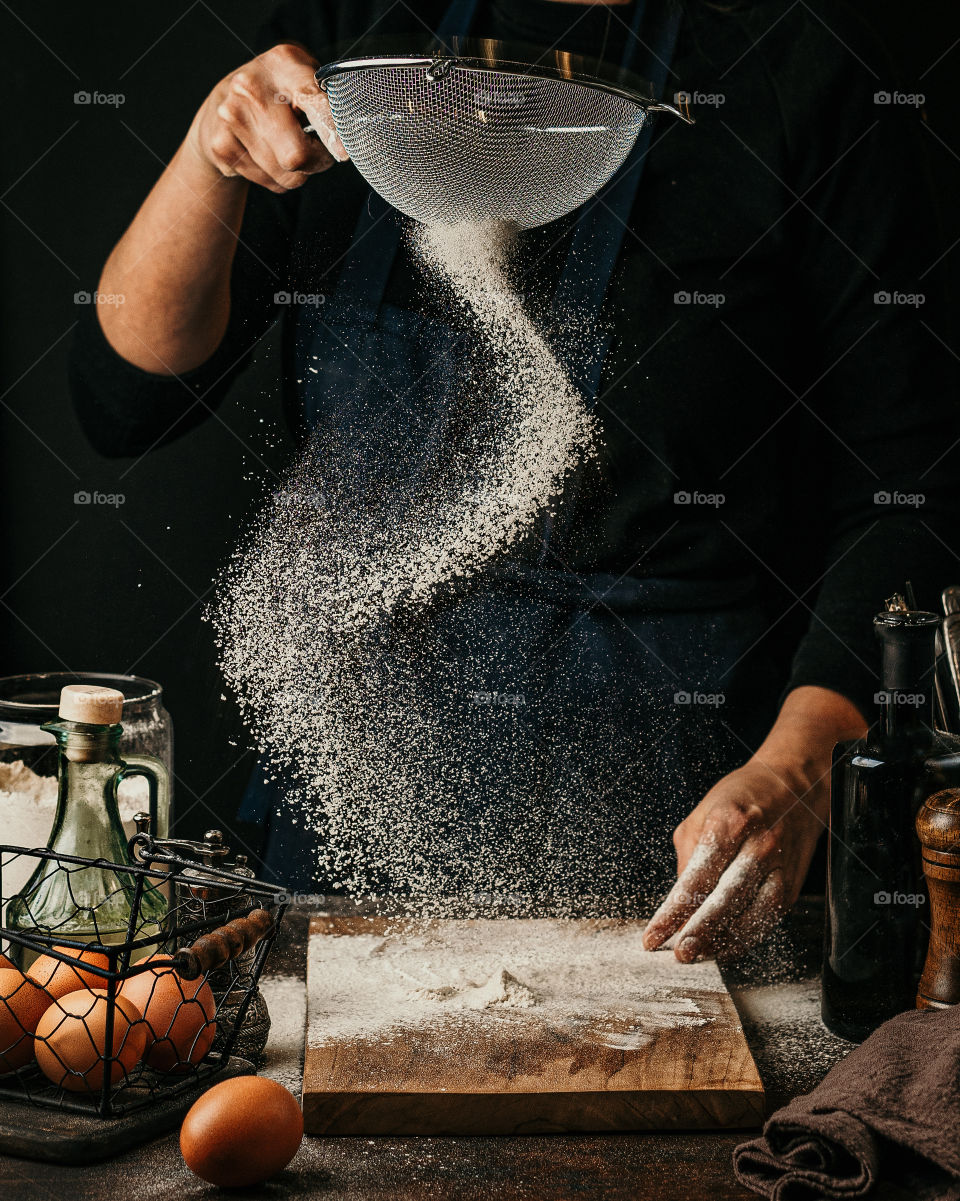 Woman sifts flour through a sieve