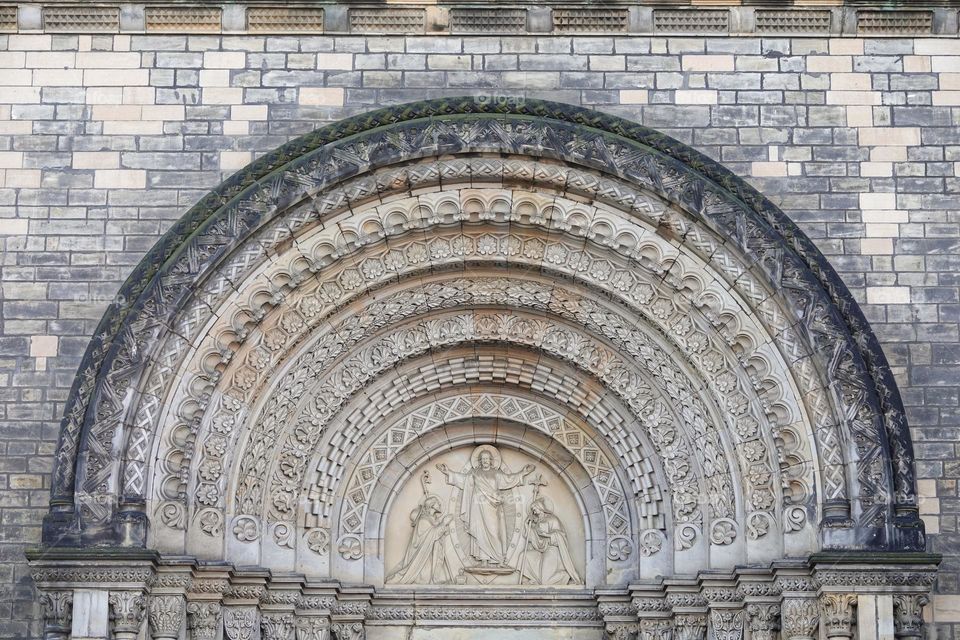 Jesus Christ blesses to Saint Cyril and Methodius. Neo-romanesque portal of old Saint Cyril and Methodius Church in Karlin, Prague, Czech Republic.