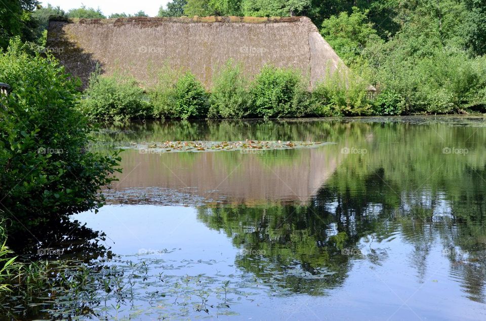 An ancient farm near a pool in Belgium.