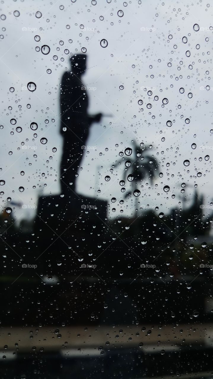 Ir. Soekarno statue when raining seen from inside of car.