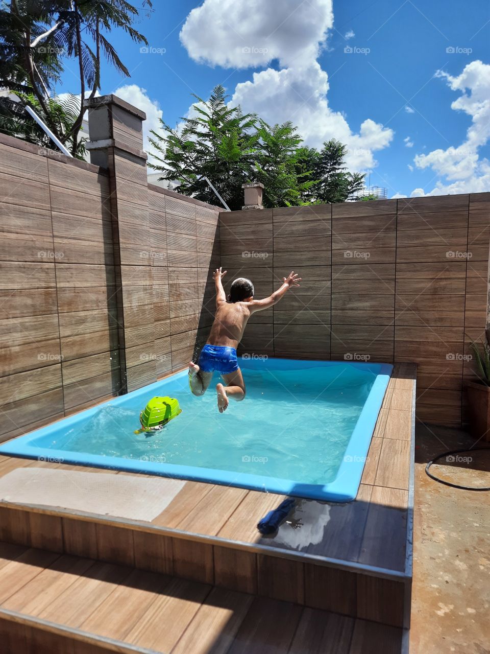 child jumping in the pool cooling off