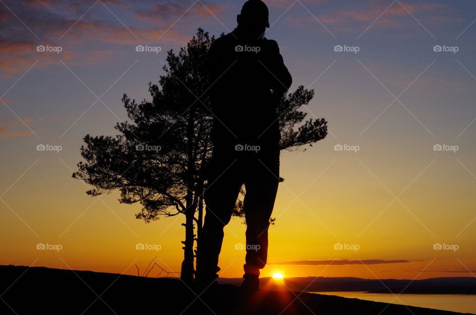 guy taking pic in sunset