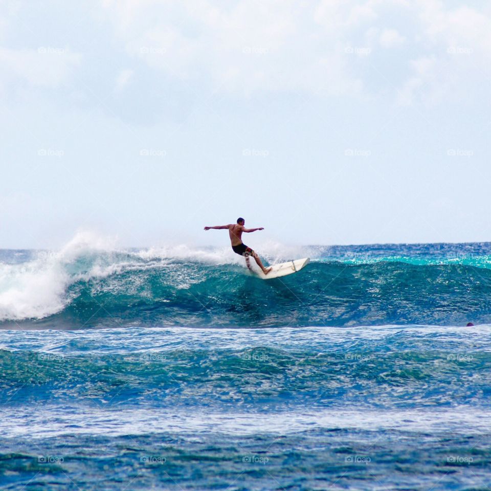 Catching some nice waves on this choppy, windy, beautiful Hawaiian afternoon in Waikiki. Surfer was so graceful in the water. Looked like that's where he belonged.  