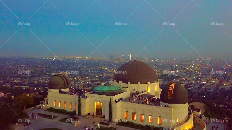 This is an aerial shot of the Griffith Observatory taken in the Hollywood Hills in Griffith Park in Hollywood, California. Overlooking Los Angeles and in the center of the background is Downtown Los Angeles. 
