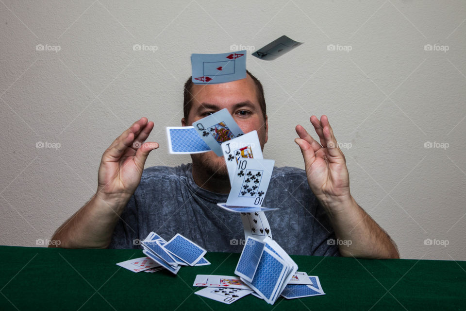 Shuffling cards. This is a photograph of a man failing at trying to shuffle cards.