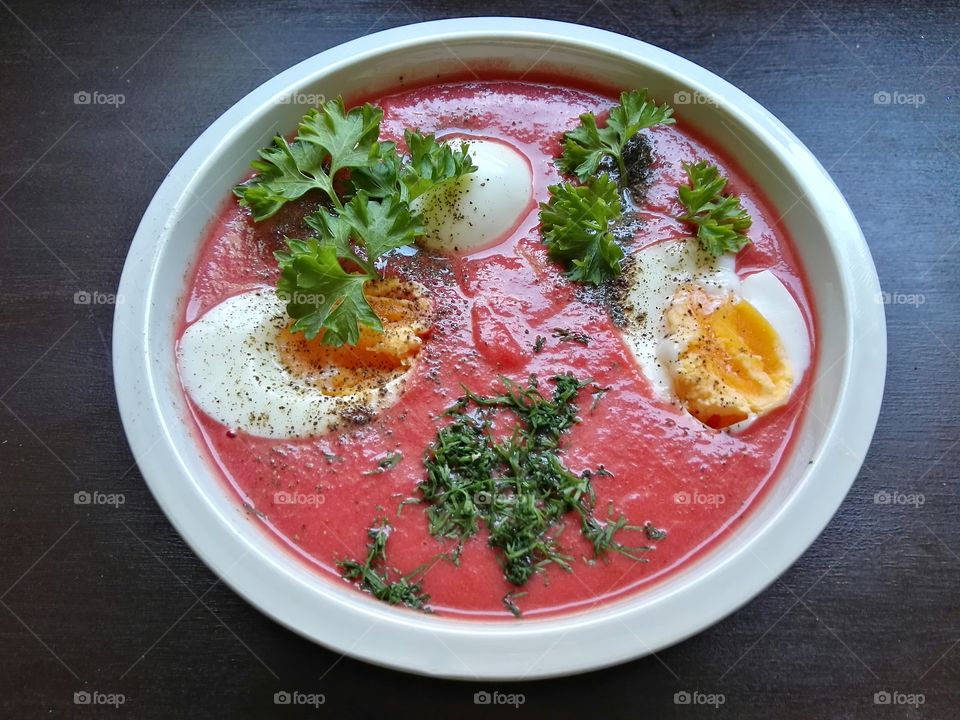 Red beet soup in a white bowl