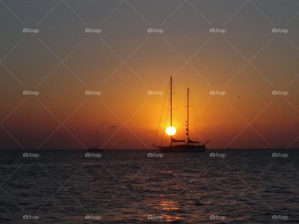 Beautiful sunset in Ibiza (I). It is like the luft of the yacht penetrated the sun when it is coming down.