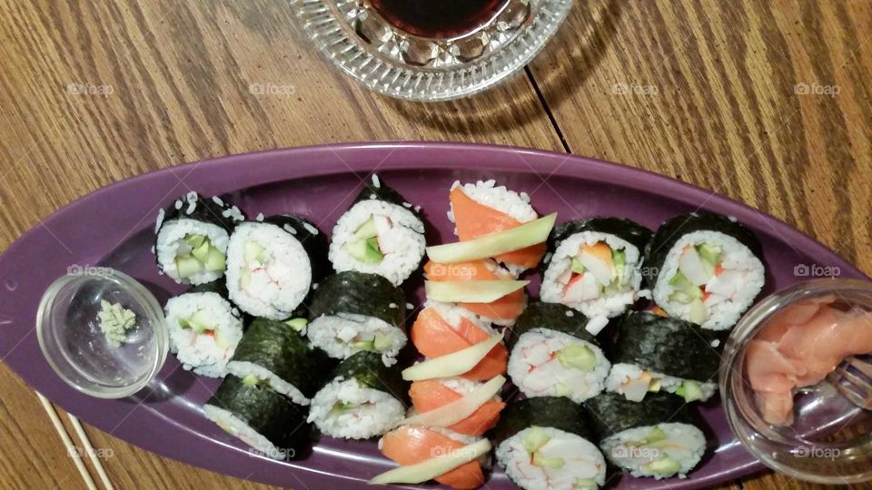 Eat more healthy homemade sushi on a  purple plated dish with Wasabi and soy sauce. Don't forget to use your chopsticks!