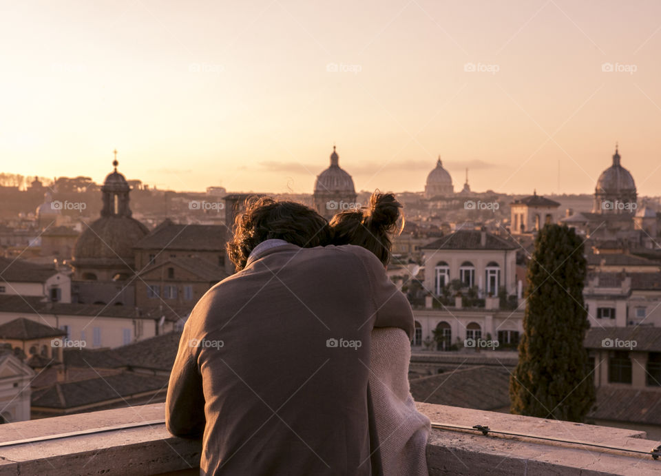 Loving couple watches the sunset in Rome