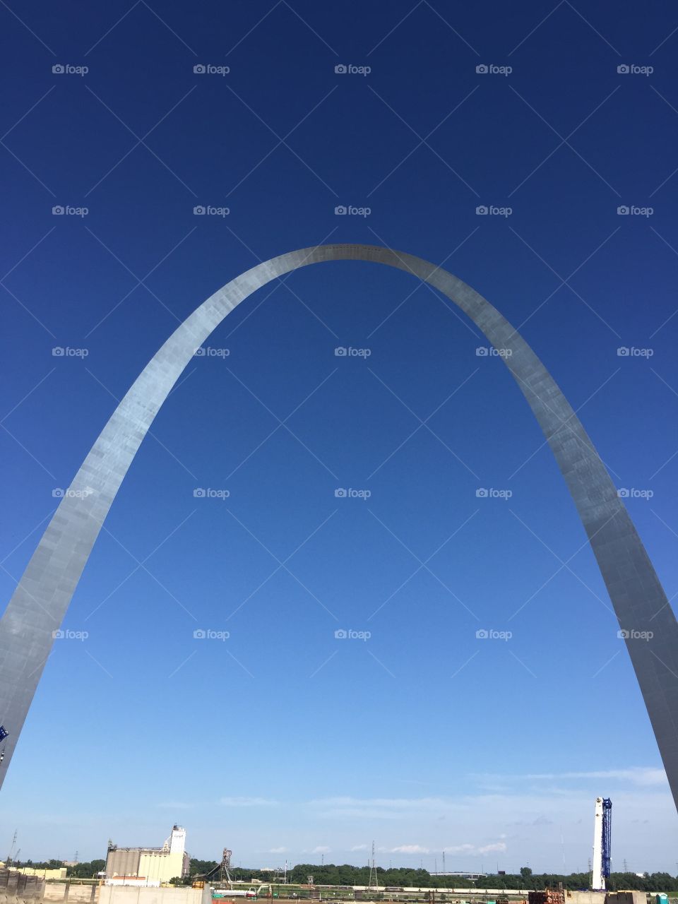 Famous tourist destination silver St. Louis Missouri arch set against cloudless blue sky