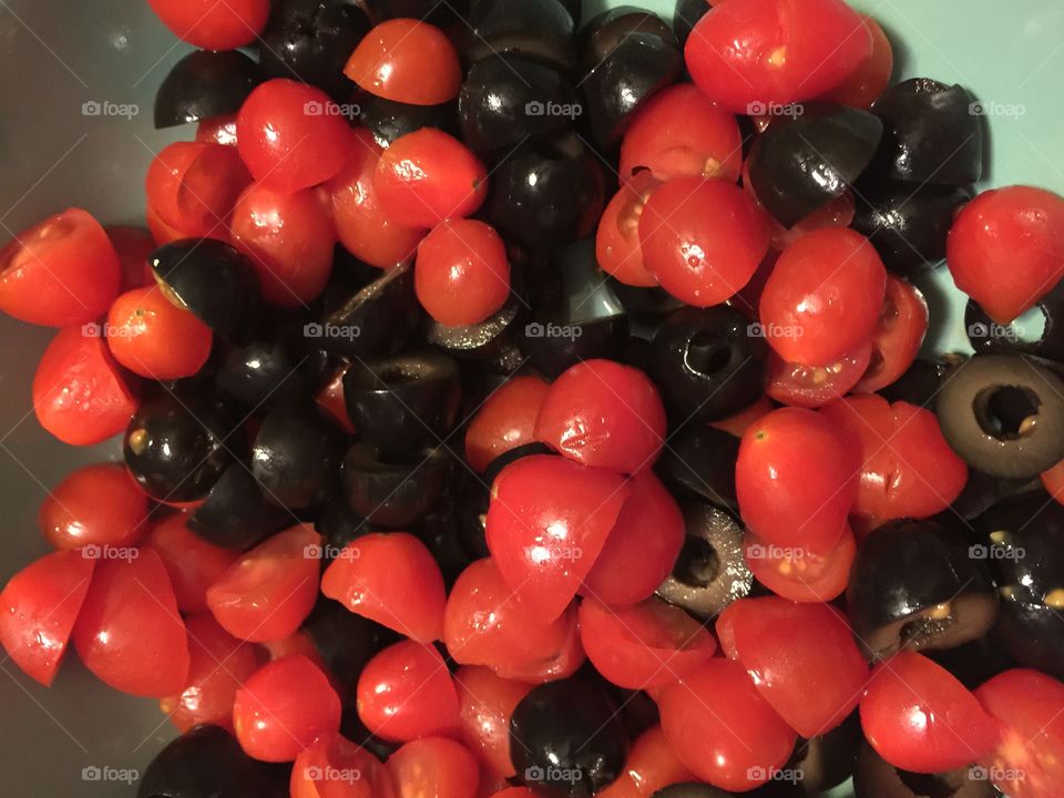 Cherry Tomatoes and black olives cut up together 