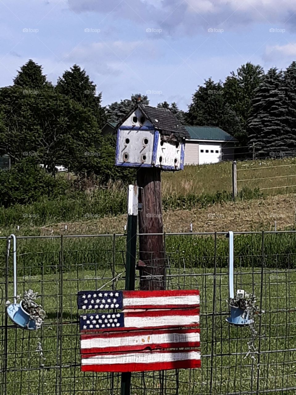 American Flag on Fence in Front of Birdhouse