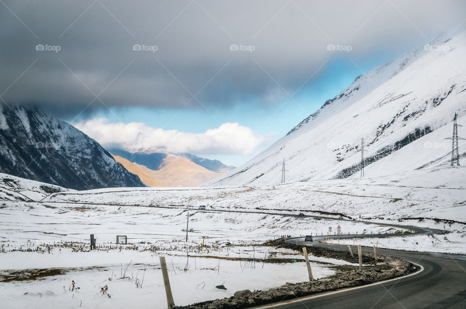 Georgian military road. The scenic winding road among the mountains in Georgia. Main Caucasian Ridge and Cross Pass Gudauri in winter.