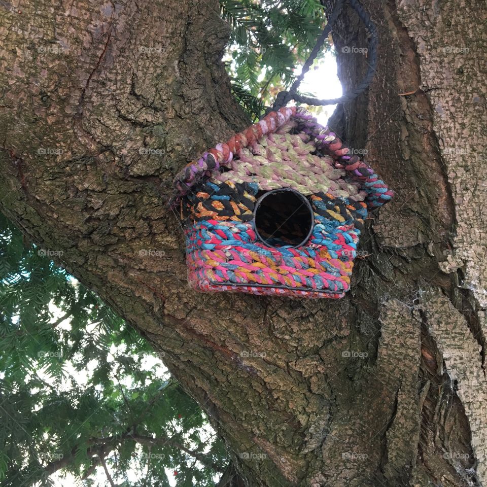 Old donated fabric cut into strips the knitted and  wrapped around a birdhouse 