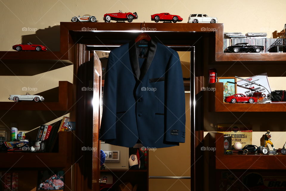 Blue tuxedo in a boy's room. Sleek blue trendy tux in a boy's room among scale cars and toys